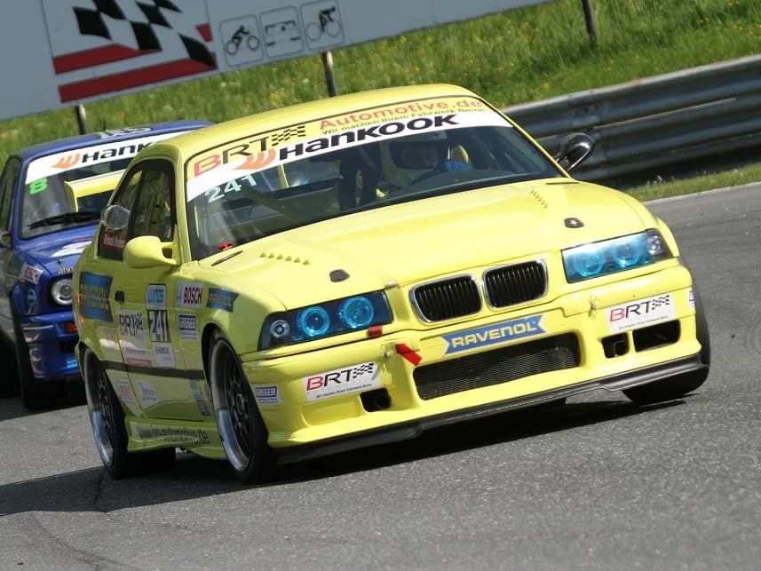 BMW E36 Coupé Rennfahrzeug mit montierter Carbon-Frontspoilerlippe auf der Rennstrecke